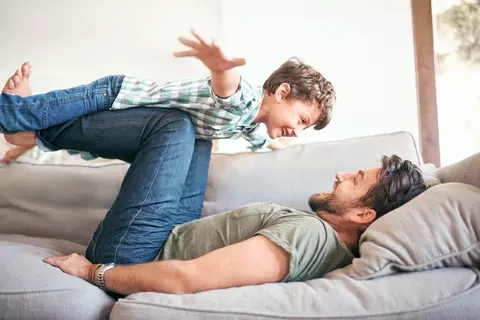 Vater und Sohn spielen auf dem Sofa 